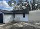 Exterior view of the home with white siding, black door, and concrete patio at 610 Illinois Ave, St Cloud, FL 34769