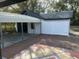 Wooden deck overlooking backyard, features white siding and a metal carport at 610 Illinois Ave, St Cloud, FL 34769