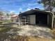 View of the open metal carport that features a gray storage unit with a large shelf at 610 Illinois Ave, St Cloud, FL 34769