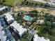 Aerial view of community with swimming pool, condos, palm trees, and vacant lots for future construction at 7503 Mourning Dove Cir # 301, Reunion, FL 34747