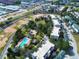 Aerial view of condos and townhomes with swimming pool, vacant lots, and commercial development close by at 7503 Mourning Dove Cir # 301, Reunion, FL 34747