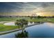 Scenic golf course view with pond, bridge, and sunset at 7503 Mourning Dove Cir # 301, Reunion, FL 34747