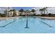 Community lap pool surrounded by palm trees and deck chairs at 7503 Mourning Dove Cir # 301, Reunion, FL 34747