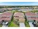 An aerial view of a two-story home in a Gathering-friendly community, complete with landscaping and attached garages at 7622 Oakmoss Loop, Davenport, FL 33837