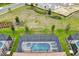 A view of a backyard pool, lawn and landscaping between the subject and the lake beyond at 7622 Oakmoss Loop, Davenport, FL 33837