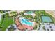 Aerial view of community pool, tennis court, and clubhouse with palm trees at 7622 Oakmoss Loop, Davenport, FL 33837