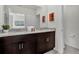 Bathroom with dual sinks, granite counters, and decorative wall art at 7622 Oakmoss Loop, Davenport, FL 33837