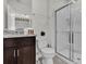 Well-lit bathroom with granite countertops and glass-enclosed shower at 7622 Oakmoss Loop, Davenport, FL 33837