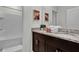 Bathroom featuring a double sink, granite countertops, and a combined tub and shower at 7622 Oakmoss Loop, Davenport, FL 33837