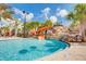 Community pool with waterslide and lounge area under a bright blue sky at 7622 Oakmoss Loop, Davenport, FL 33837