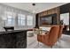 Modern living room with a unique light fixture, wood paneled accent wall, sleek furniture and large windows at 7622 Oakmoss Loop, Davenport, FL 33837