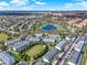 Scenic aerial view of townhomes surrounding a pond in a lush, well-maintained community on a sunny day at 7682 Fitzclarence St, Kissimmee, FL 34747