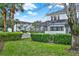 A view of the backyard with a screened lanai, lush greenery, and well-maintained landscaping at 7682 Fitzclarence St, Kissimmee, FL 34747