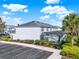 Exterior view of a residential building featuring a screened-in lanai and surrounding landscaping at 7682 Fitzclarence St, Kissimmee, FL 34747