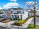 Townhome featuring blue shutters, neutral paint, manicured landscaping, and driveway at 7682 Fitzclarence St, Kissimmee, FL 34747