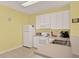 Bright kitchen with white appliances, ample counter space, and tile flooring at 7682 Fitzclarence St, Kissimmee, FL 34747