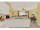 Open kitchen design overlooking the living area with white cabinets, countertop, and view of the screened-in pool at 7682 Fitzclarence St, Kissimmee, FL 34747