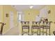 Functional kitchen area featuring bar stool seating, white cabinets, and tile flooring at 7682 Fitzclarence St, Kissimmee, FL 34747