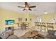 Inviting living room featuring a ceiling fan, TV, dining area, and bar seating for entertaining guests at 7682 Fitzclarence St, Kissimmee, FL 34747