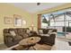 Cozy living room featuring comfortable sofas, a coffee table, and a view of the screened-in pool area at 7682 Fitzclarence St, Kissimmee, FL 34747