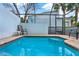 Private outdoor pool area featuring brick patio, privacy wall, seating, and screen enclosure at 7682 Fitzclarence St, Kissimmee, FL 34747