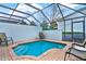 Private pool area with brick surround, outdoor seating, and enclosed screen at 7682 Fitzclarence St, Kissimmee, FL 34747