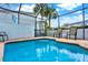 Relaxing screened-in pool area with comfortable chairs and palm trees, perfect for enjoying the Florida sunshine at 7682 Fitzclarence St, Kissimmee, FL 34747