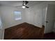 This bedroom features hardwood floors, white walls, natural light and a closet at 7709 Bell Blvd, Orlando, FL 32810