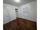 This bedroom features hardwood floors, white walls, natural light and a closet at 7709 Bell Blvd, Orlando, FL 32810