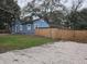 Cozy blue home featuring a fenced yard for privacy and a spacious driveway for convenient parking at 7709 Bell Blvd, Orlando, FL 32810