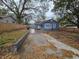 Exterior shot showcasing the well manicured lawn, long driveway, and craftsman-style design at 7709 Bell Blvd, Orlando, FL 32810