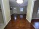 Hallway with hardwood floors leads to a bright and airy living room with natural light at 7709 Bell Blvd, Orlando, FL 32810