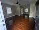 A light and airy living room boasts lustrous hardwood floors, ceiling fan and natural light at 7709 Bell Blvd, Orlando, FL 32810