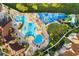 Aerial view of a resort-style pool, splash zone and sun deck with lounge chairs and umbrellas at 7761 Tosteth St, Kissimmee, FL 34747