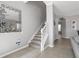 Inviting foyer showcasing a staircase, decorative mirror, and neutral color palette at 7761 Tosteth St, Kissimmee, FL 34747