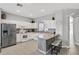 Bright kitchen featuring white cabinetry, stainless steel appliances, tile backsplash, and a breakfast bar at 7761 Tosteth St, Kissimmee, FL 34747