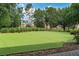 Putting green with artificial turf for practice, surrounded by mature landscaping at 7761 Tosteth St, Kissimmee, FL 34747