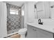 Updated bathroom with black and grey patterned tile in shower with a modern vanity at 802 S 10Th St, Haines City, FL 33844