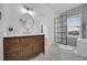 Well-lit bathroom featuring a wood vanity, white countertop, a round mirror and a black framed shower with decorative tile at 802 S 10Th St, Haines City, FL 33844