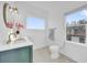 Bright bathroom featuring a toilet, and a vanity sink with a window view of a house at 802 S 10Th St, Haines City, FL 33844