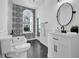 Modern bathroom featuring black and white ornate tile, a large arched window, and a white vanity at 802 S 10Th St, Haines City, FL 33844