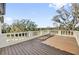 Large outdoor wooden deck with white concrete railing overlooking a treed landscape at 802 S 10Th St, Haines City, FL 33844