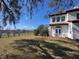 Exterior view of a white home shows lawn and trees at 802 S 10Th St, Haines City, FL 33844