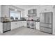 Well-lit kitchen featuring white cabinets, stainless steel appliances, and black countertops at 802 S 10Th St, Haines City, FL 33844