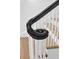 Close-up of a black handrail, white spindles and wooden steps at 802 S 10Th St, Haines City, FL 33844