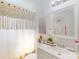 Bright bathroom with natural-toned macrame shower curtain and flower accents at 8101 Dominguin St, Orlando, FL 32817