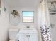 Well-lit bathroom with classic white vanity, sink, and shower with stylish curtain at 8101 Dominguin St, Orlando, FL 32817