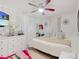 Bright bedroom with white sheer curtains, ceiling fan, television and light wood grain floor at 8101 Dominguin St, Orlando, FL 32817