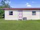 Exterior view of home with light yellow siding, pink trim, and a well-maintained lawn at 8101 Dominguin St, Orlando, FL 32817