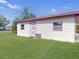 Exterior view of home with light yellow siding, pink trim, and a well-maintained lawn at 8101 Dominguin St, Orlando, FL 32817